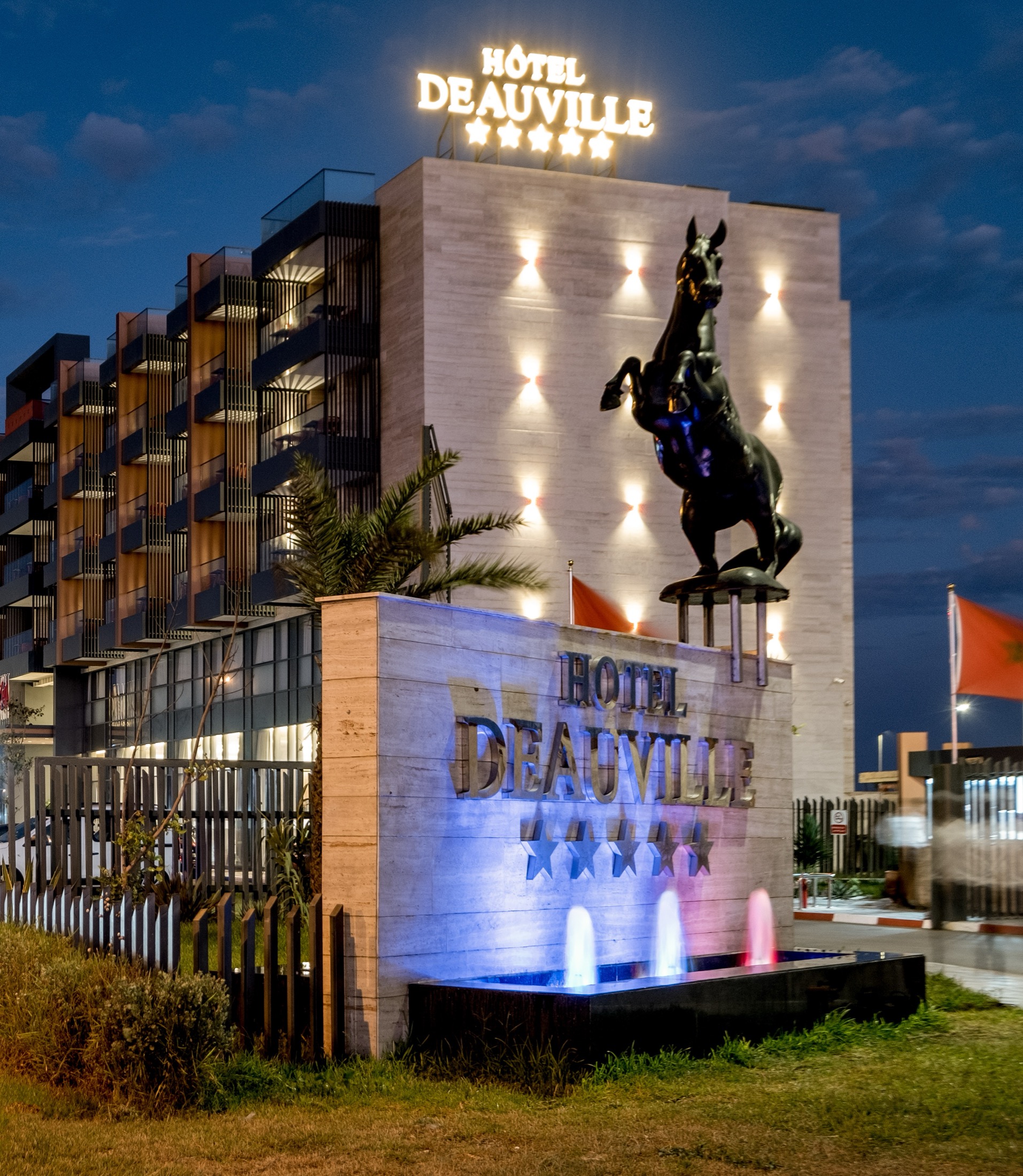 Le cheval de l'Hôtel Deauville et l'enseigne, à la nuit tombée