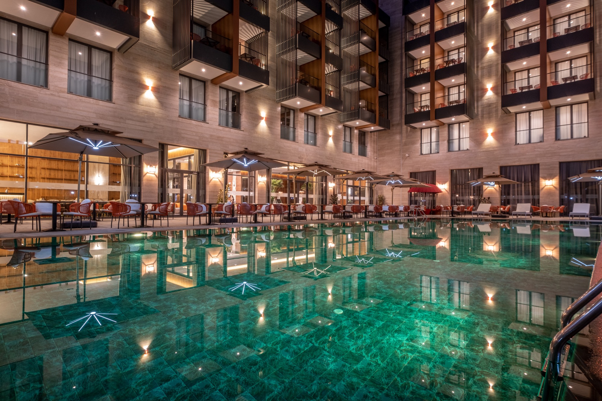La piscine et ses tables, face aux jardins